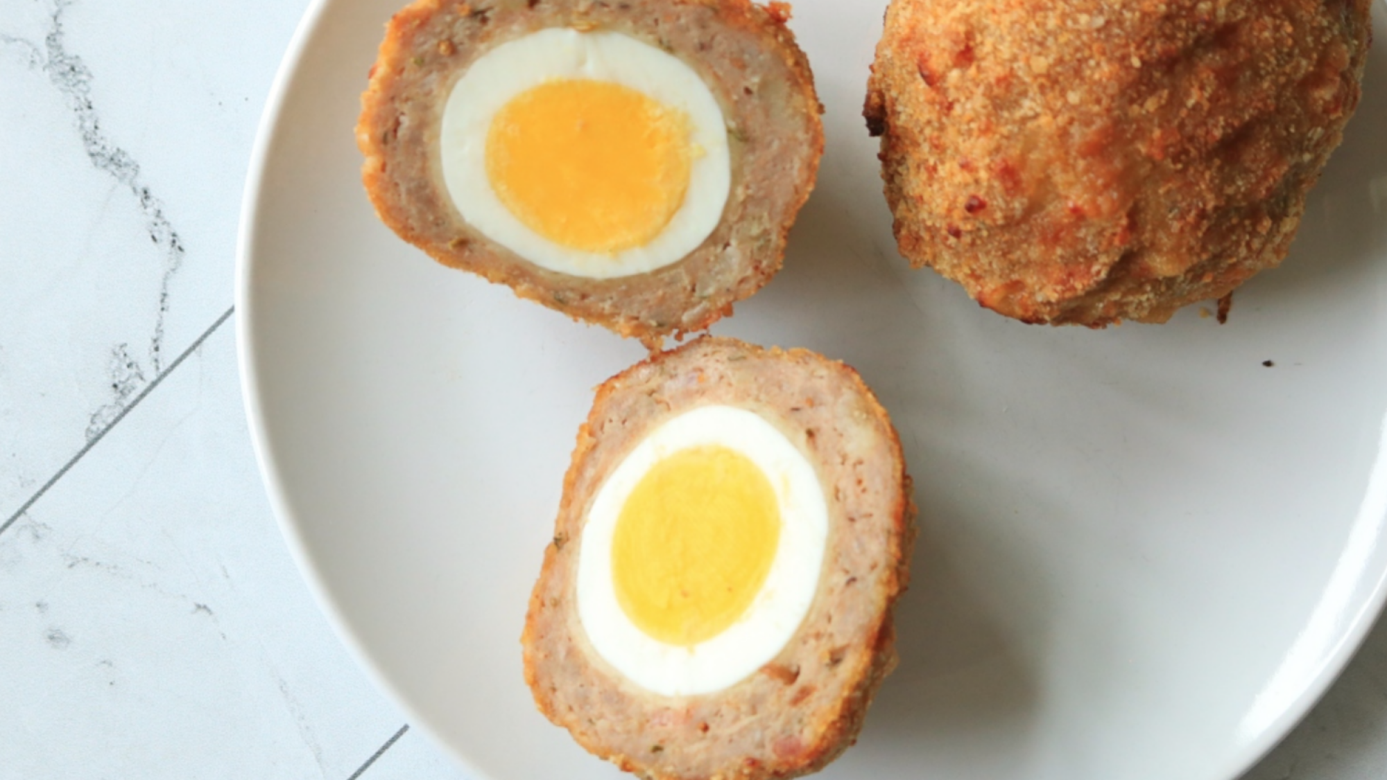 Scotch eggs on a plate.